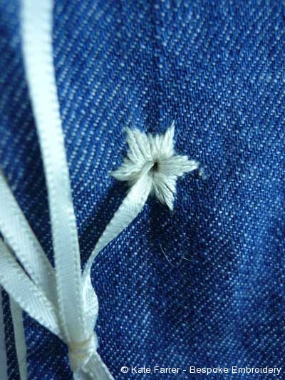 Star whitework hand embroided eyelet on denim as a book binding